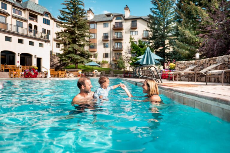 father and son playing in a pool at the Charter Colorado